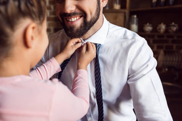istock daughter buttoning shirt for father 925685010
