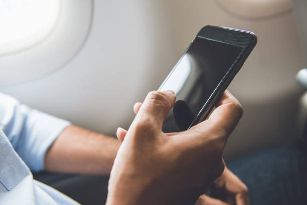 il passeggero ha appena spento il telefono cellulare sull'aereo mentre viaggiava per un volo sicuro - airplane smart phone travel mobile phone foto e immagini stock