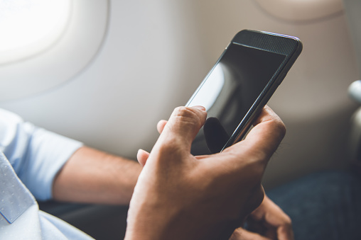 Passenger just turned off mobile phone on the airplane while traveling for safe flight