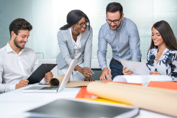 istock Group of young perspective architects looking at project papers in the office. 925688892