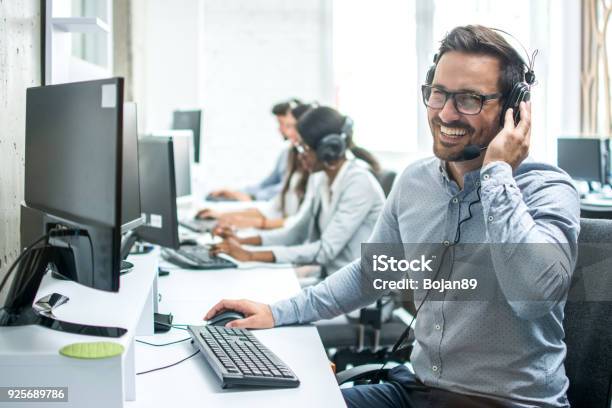 Smiling Handsome Customer Support Operator With Headset Working In Call Center Stock Photo - Download Image Now