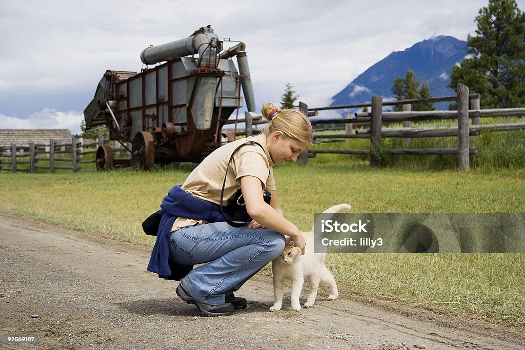 Giovane donna con un gatto - Foto stock royalty-free di Abbigliamento