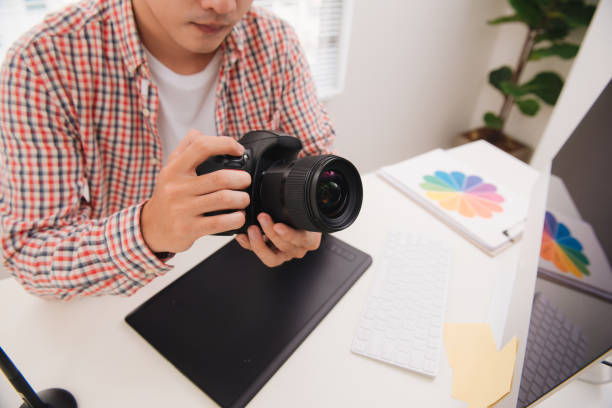 istock Photographer working at desk in modern office 925694374