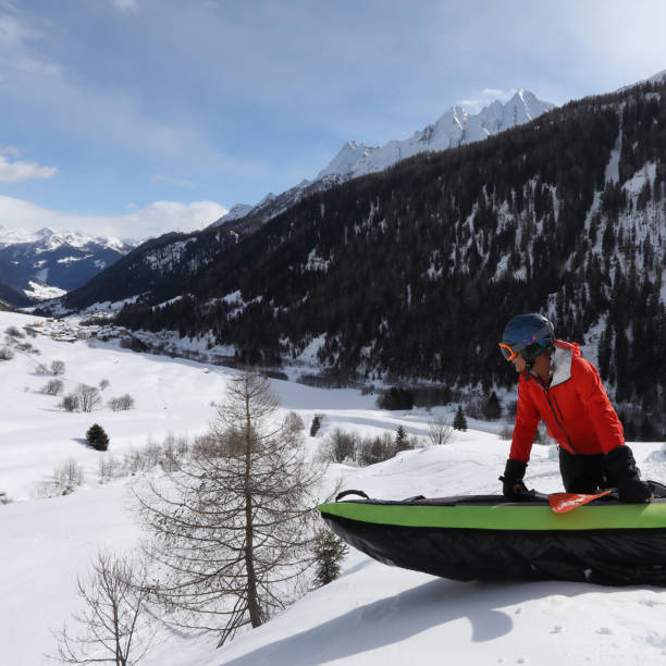 mann hält neben aufblasbaren kajak auf schnee gipfel - clothing anticipation central europe switzerland stock-fotos und bilder