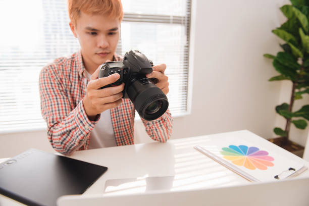 istock Photographer working at desk in modern office 925697350