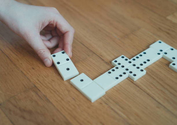 istock Child playing dominoes on the floor. Close-up view. 925697736