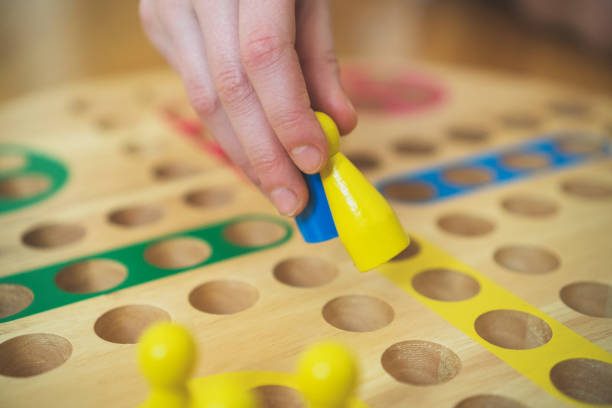 dziecko gra w grę planszową ludo. widok z bliska. - board game marker zdjęcia i obrazy z banku zdjęć