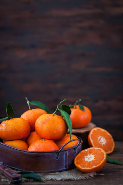 istock Fresh tangerines with leaves on  wooden table 925701524
