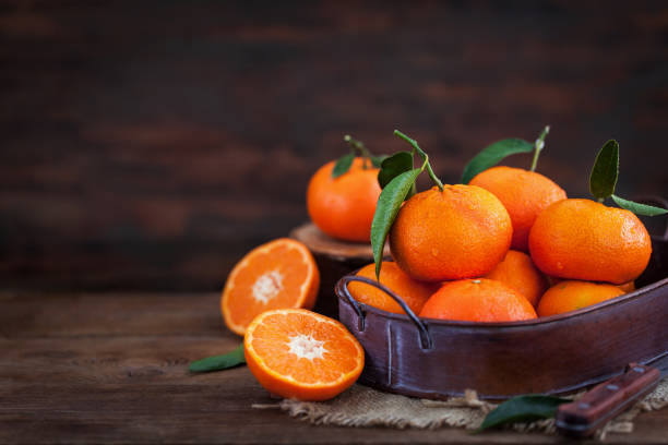 istock Fresh tangerines with leaves on  wooden table 925701528