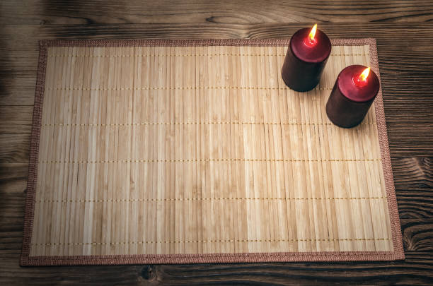 Two burning candles on wooden desk table surface background with copy space. Romantic dinner table in candle lights.