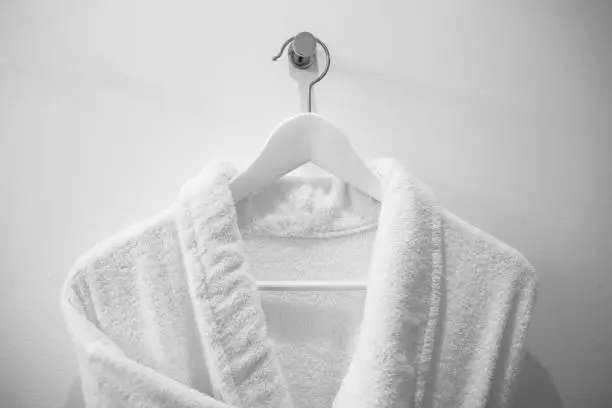 Photo of White robe on the hanger in the bathroom.