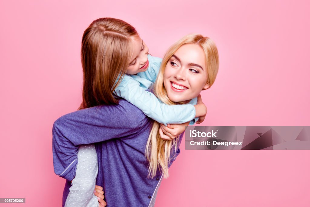 스튜디오 초상화 가까이 어머니를 웃 고 뒤에 그녀의 딸 그들은 서로 게 입은 잠 옷 수 면 준비 시간을 함께 보내는 핑크 배경 ...