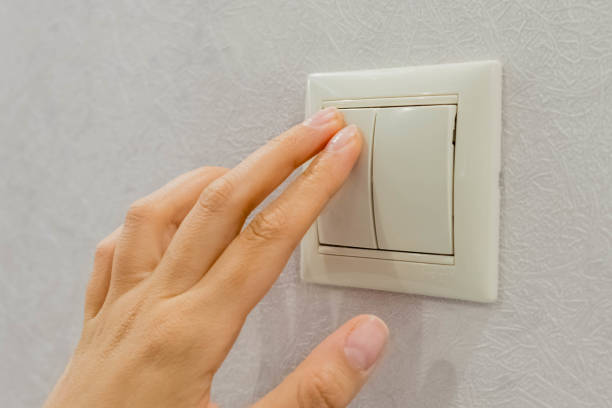 istock save energy - switch off. Close up of finger is turning on or off on light switch. Copy space. 925705708