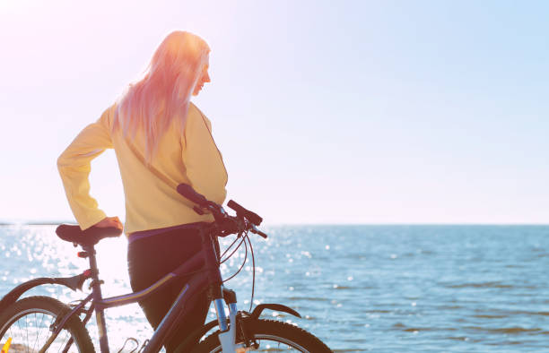 istock A girl on a bicycle by the sea 925709086