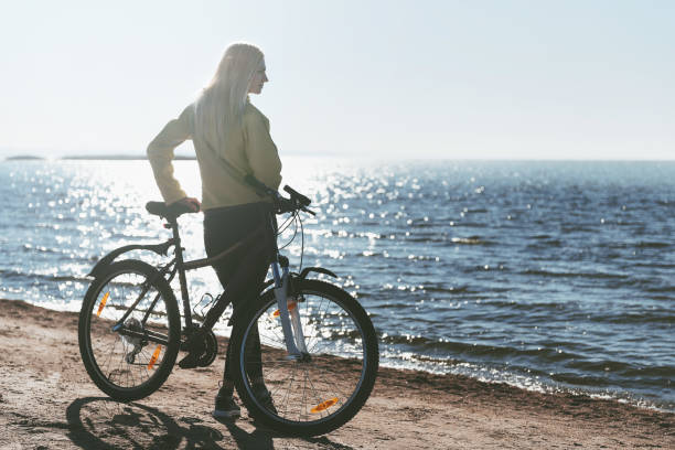 istock A girl on a bicycle by the sea 925709090