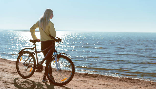 istock A girl on a bicycle by the sea 925709094