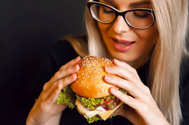 istock The girl is eating a burger 925709272