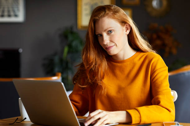 istock Confident young woman using laptop at home 925709904