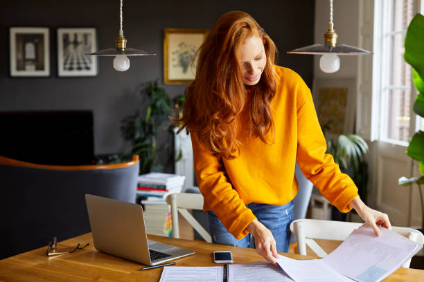 istock Businesswoman reading documents at table in home 925709952