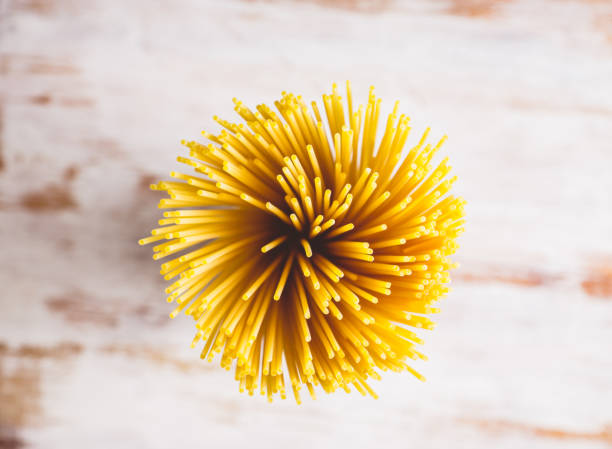 istock Raw pasta on the rustic wooden background 925710076