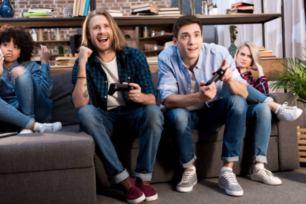istock men playing video game and multicultural girls sitting upset 925712622
