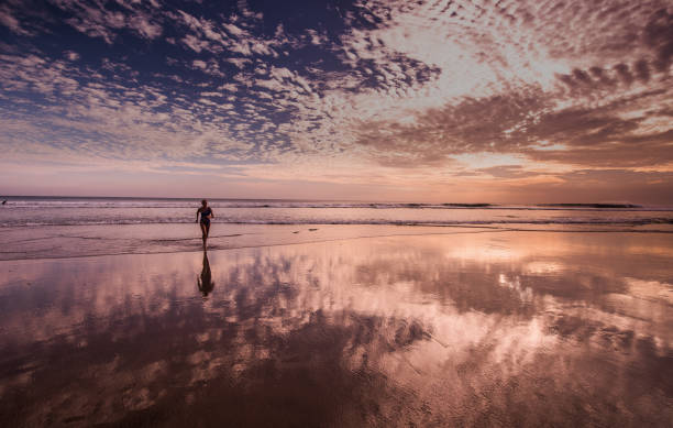 istock Woman walking by sea coast. 925713250