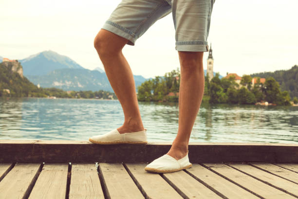 istock Handsome man standing on the wooden board on the lake. 925713276