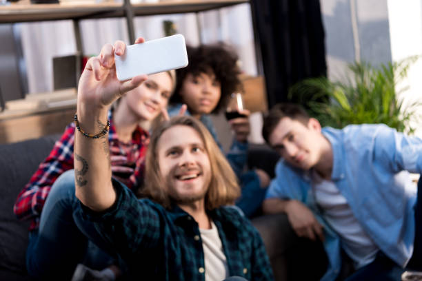 istock multicultural friends taking selfie on sofa at home 925713720