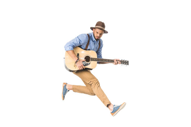 istock handsome young man in hat playing guitar and jumping isolated on white 925714840