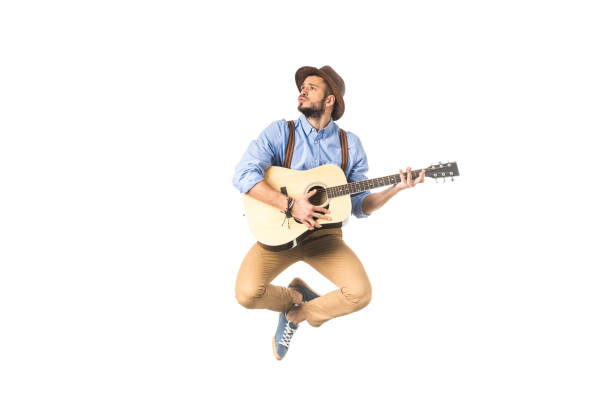 istock romantic young musician looking away while playing guitar and jumping isolated on white 925717392