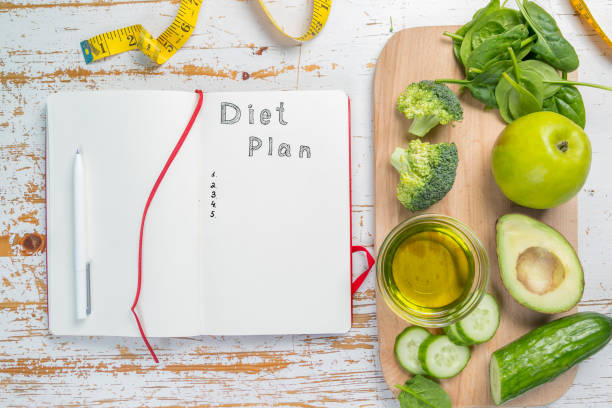 istock Diet plan concept - selection of green food and note pad 925721972