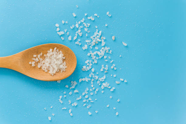 istock sea salt on a bamboo spoon on a blue background. 925722796