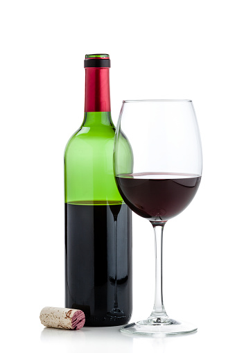 Front view of a wineglass with an open half full wine bottle behind it shot on reflective white background. The bottle is green colored with a red collar. The cork is laying beside the bottle. High key DSRL studio photo taken with Canon EOS 5D Mk II and Canon EF 70-200mm f/2.8L IS II USM Telephoto Zoom Lens