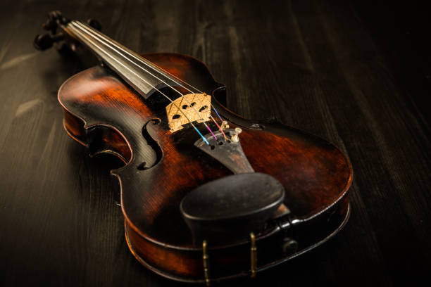 violín antiguo estilo vintage sobre fondo de madera - musical instrument string music dark old fashioned fotografías e imágenes de stock
