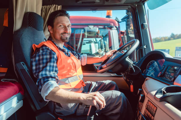 водитель грузовика или грузовика сидит в салоне своего автомобиля - тяжелое товарное средство передвижения стоковые фото и изображения