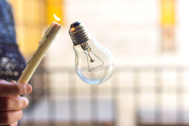 istock woman hold a candle for illuminate a bulb 925737822