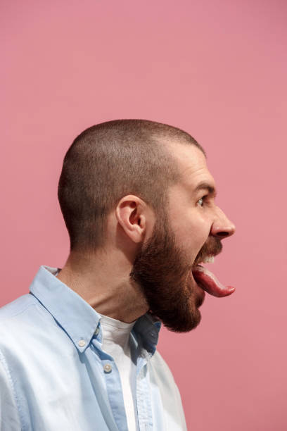 istock The young emotional angry, crazy man on pink studio background 925745952