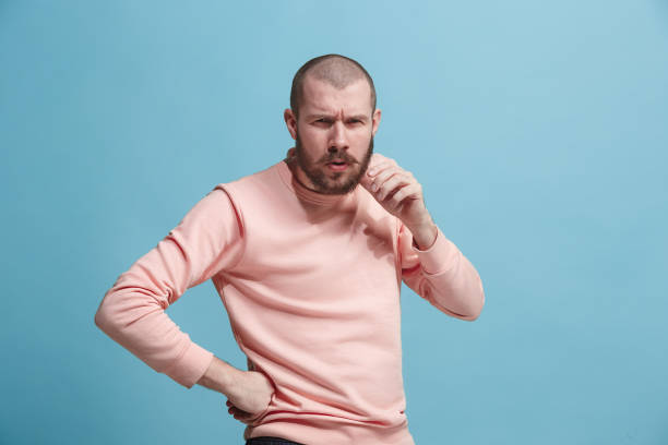 istock Suspiciont. Doubtful pensive man with thoughtful expression making choice against blue background 925749480