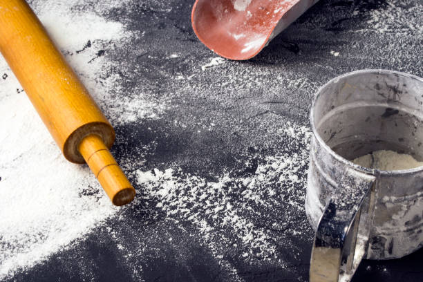 istock Rolling pin and white flour on a dark background. Free space for text . 925749748