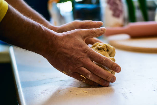 istock Skillful man's hands roll out dough on the white table 925750306