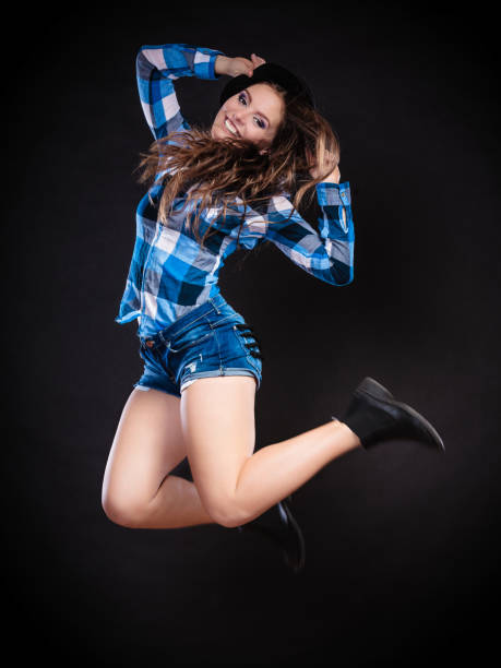istock Happy woman jumping on black 925758600