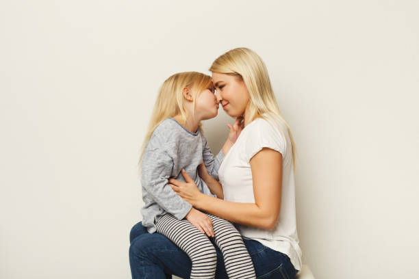 istock Happy mother and daughter embracing at white studio background 925763030