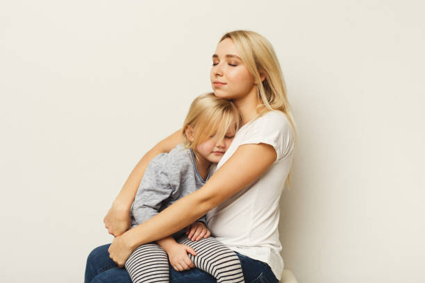 istock Happy mother and daughter embracing at white studio background 925763076