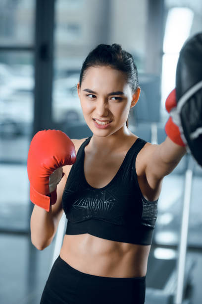 istock expressive young female boxer training at gym 925763788