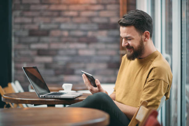 Young man sitting in cafeteria. Young man sitting in cafeteria and using tablet computer cafe tablet stock pictures, royalty-free photos & images