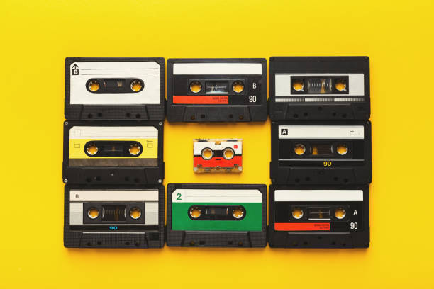 istock Big retro cassettes framing a small one on yellow background, top view, copy space 925767736