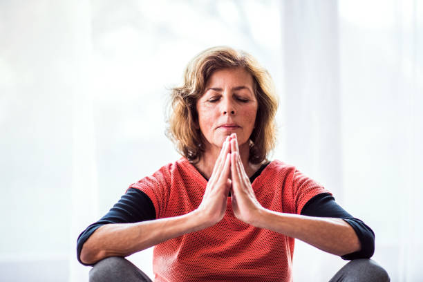 istock Senior woman meditating at home. 925771490