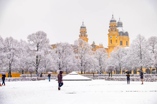 雪の嵐の間に、ドイツのミュンヘンで地下鉄オーデオンシュプラッツを楽しむ人々 - church in the snow ストックフォトと画像