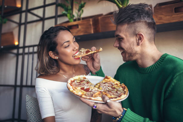 istock Mixed race couple eating pizza in cafe 925786722