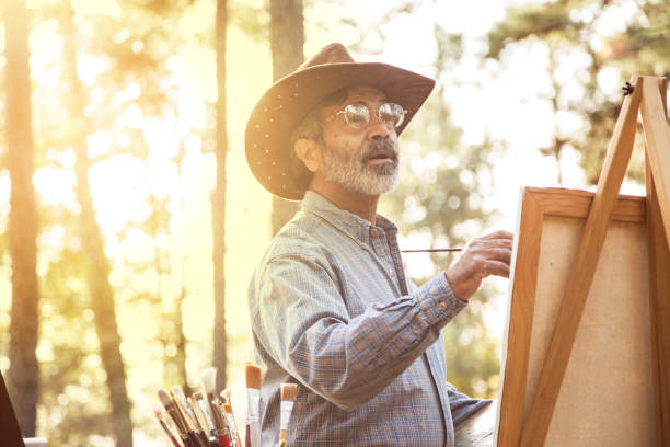 l'uomo adulto senior attivo ama l'hobby artistico all'aperto. - uomo dipinge foto e immagini stock